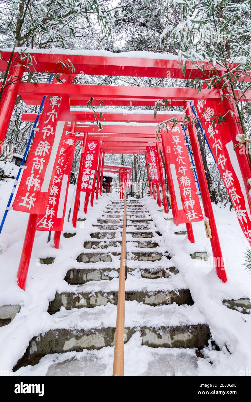Spettacolare ingresso rosso torii del Santuario Ana Mori Inari al Parco Sainokawara, Kusatsu all'aperto Onsen, Giappone. Foto Stock