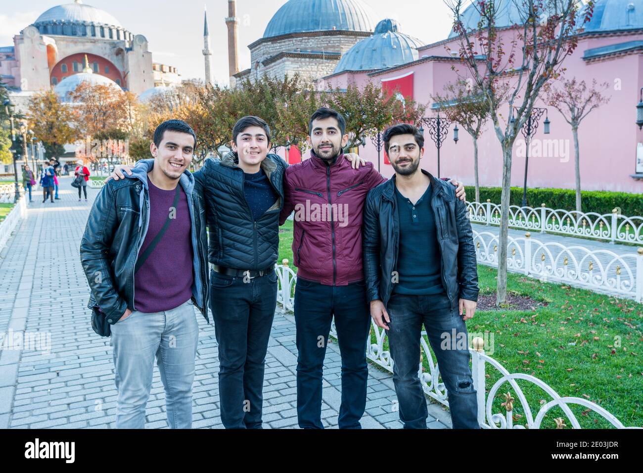 Quattro uomini turchi si trovano di fronte alla moschea di Hagia Sophia al mattino contro il cielo blu in autunno a Istanbul, Turchia Foto Stock
