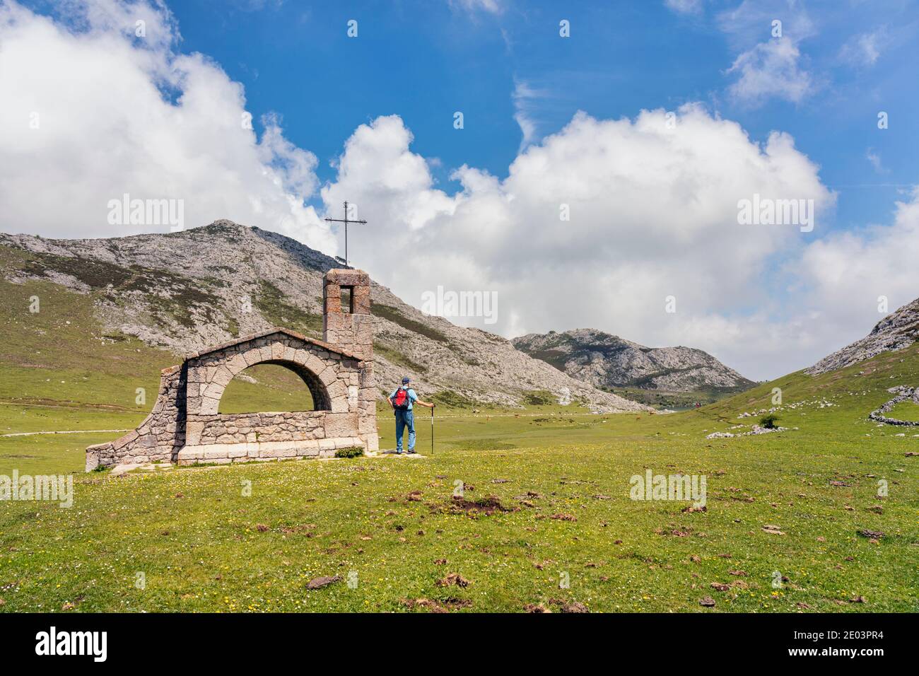 Escursionista all'Ermita del Pastor, Parque Nacional de los Picos de Europa, Asturias, Spagna. Cappella del buon Pastore, picchi del Parco Nazionale d'Europa. Foto Stock