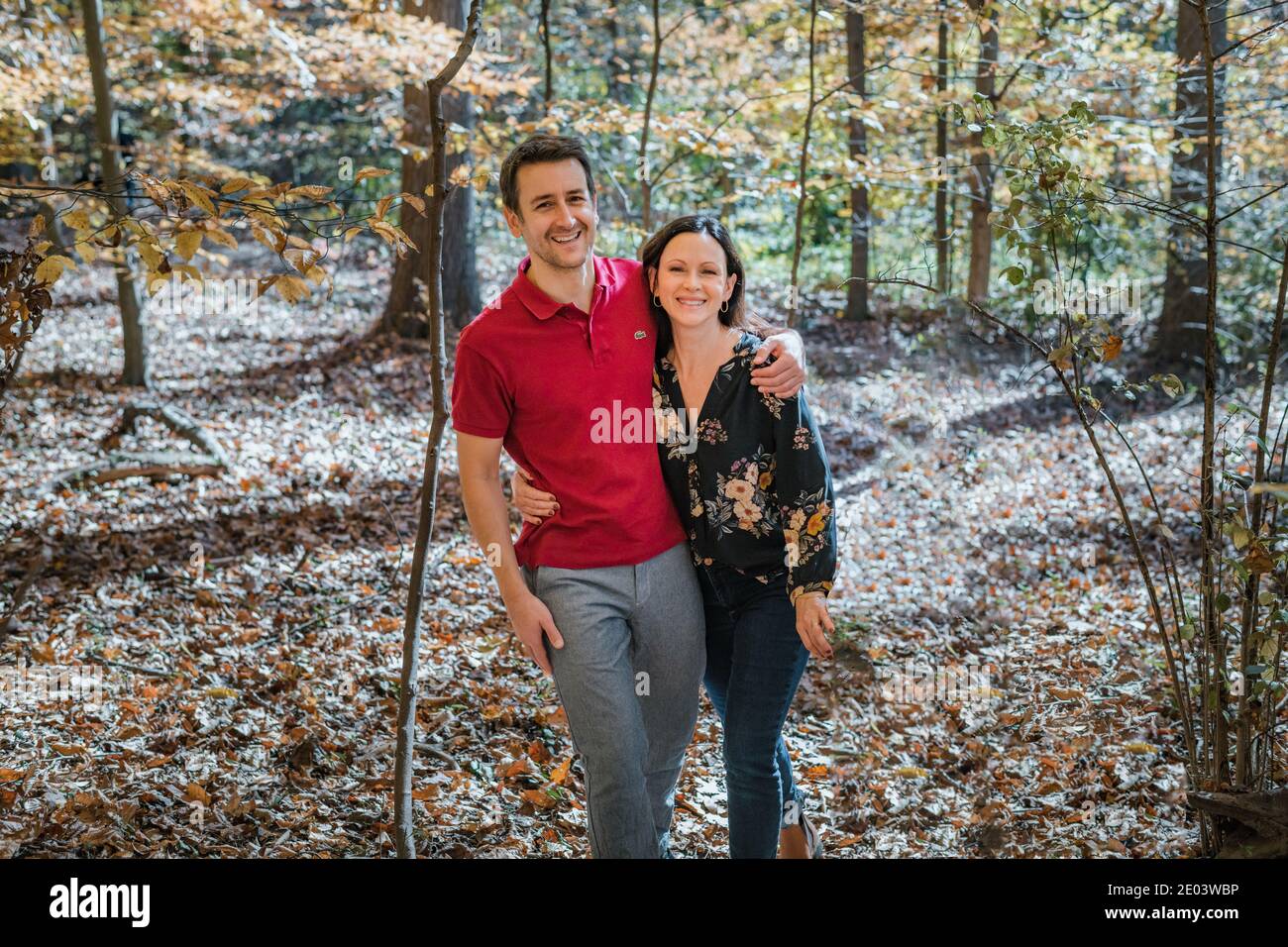 Coppia adulta sorridente insieme e abbracciante nella foresta Foto Stock
