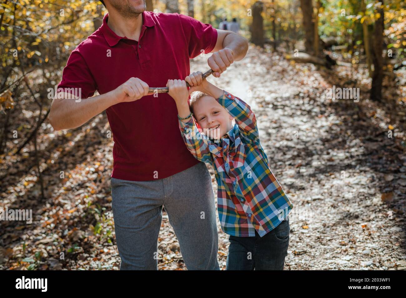 Padre e figlio giocano con il ramo dell'albero Foto Stock