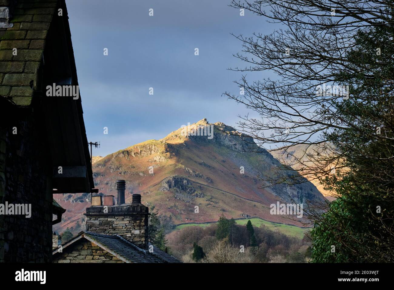 Sunlit Helm Crag visto da Town End, Grasmere, Lake District, Cumbria Foto Stock