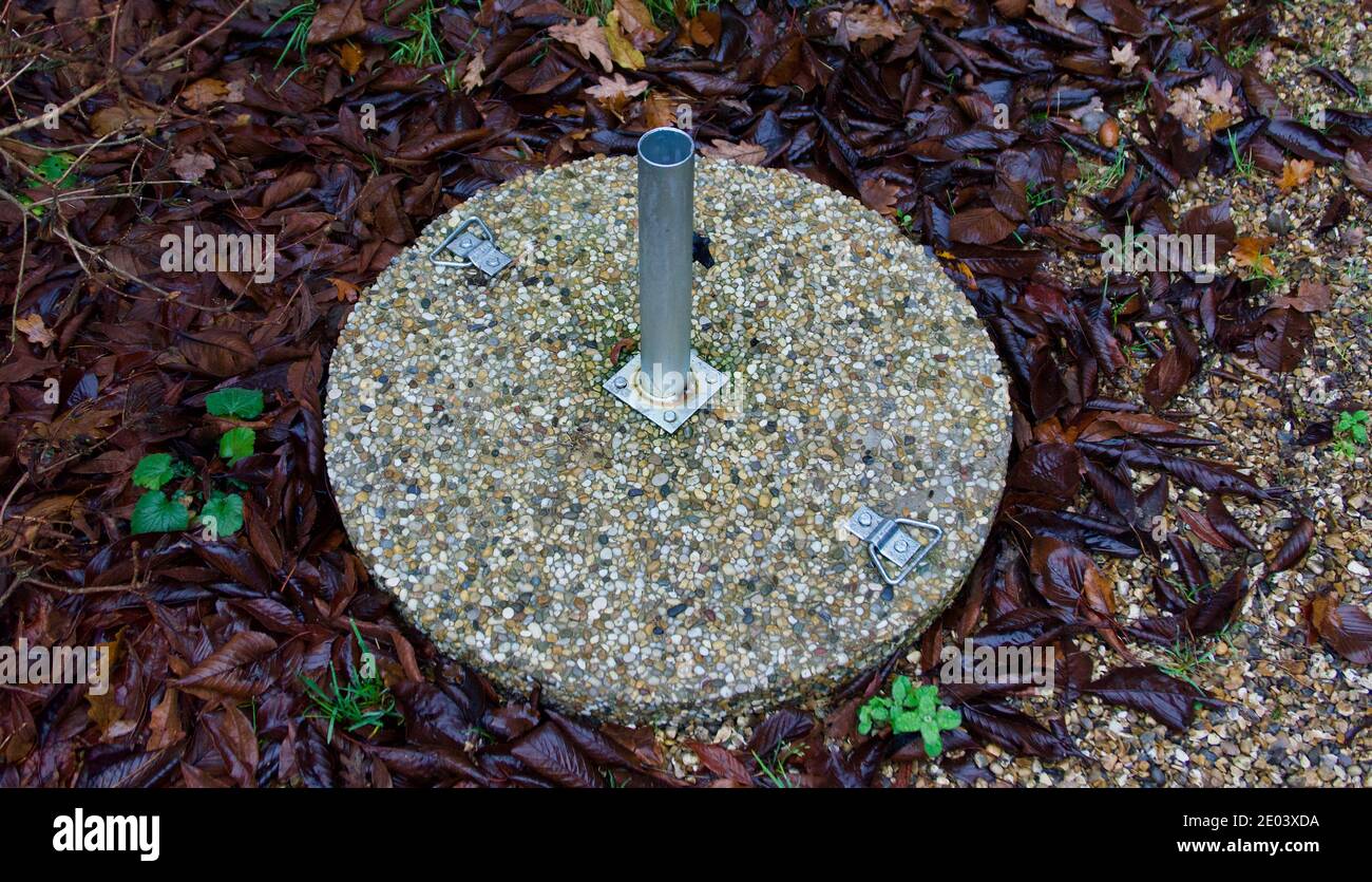 Base in cemento e metallo per il parasolo per sedersi sotto il tavolo Foto Stock