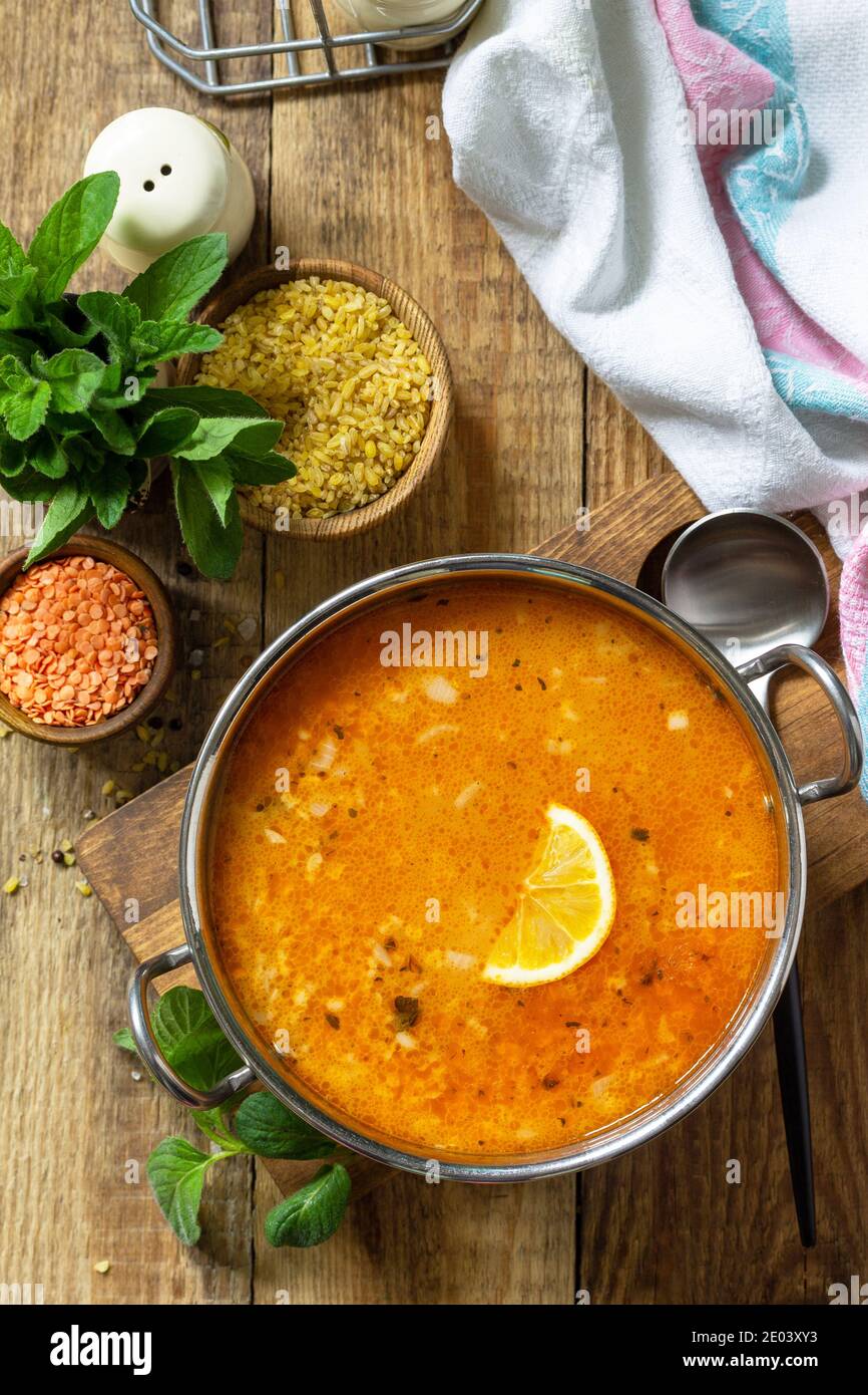 Cucina turca. Zuppa tradizionale con riso, lenticchie e menta su un tavolo rustico. Vista dall'alto in piano. Foto Stock