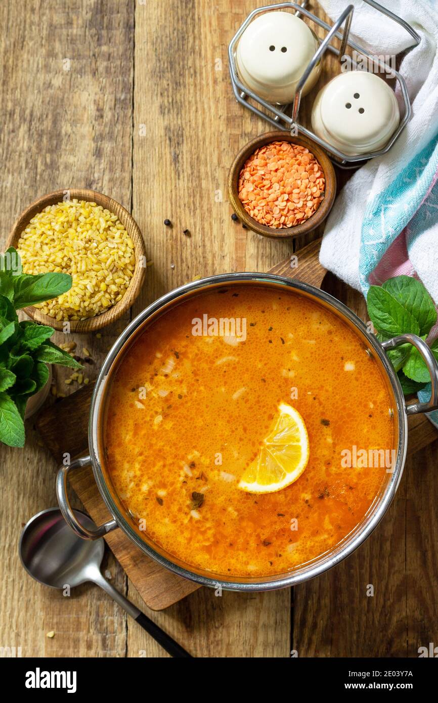 Cucina turca. Zuppa tradizionale con riso, lenticchie e menta su un tavolo rustico. Vista dall'alto in piano. Spazio di copia. Foto Stock