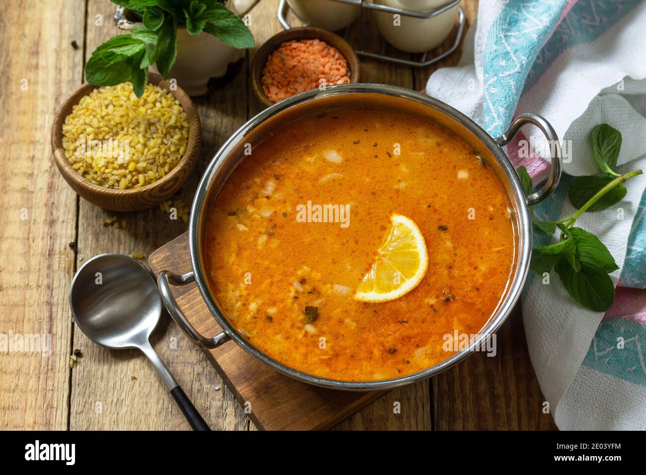 Cucina turca. Zuppa tradizionale con riso, lenticchie e menta su un tavolo rustico. Foto Stock