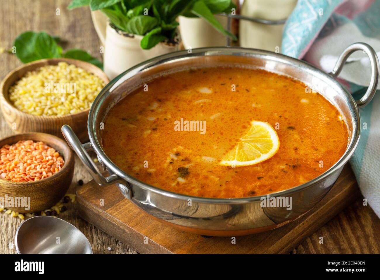 Cucina turca. Zuppa tradizionale con riso, lenticchie e menta su un tavolo rustico. Foto Stock