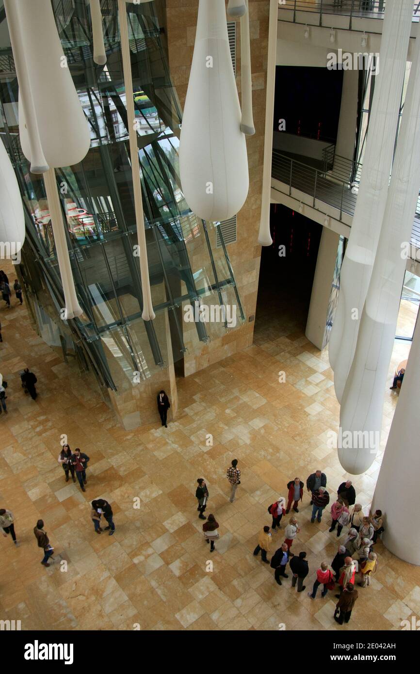 La guida turistica spiega ai visitatori l'enorme interno del Museo Guggenheim, la hall con vista dall'alto. Foto Stock