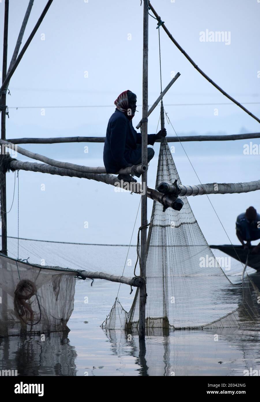 Guwahati, Assam, India. 29 Dic 2020. I pescatori indiani si siedono in una barca di campagna e pescano il pesce nel fiume Brahmaputra a Gauhati, India, martedì 29 dicembre 2020. Il fiume Brahmaputra è uno dei fiumi più grandi dell'Asia, che scorre dalla regione cinese del Tibet ed entra in India Credit: Dasarath Deka/ZUMA Wire/Alamy Live News Foto Stock