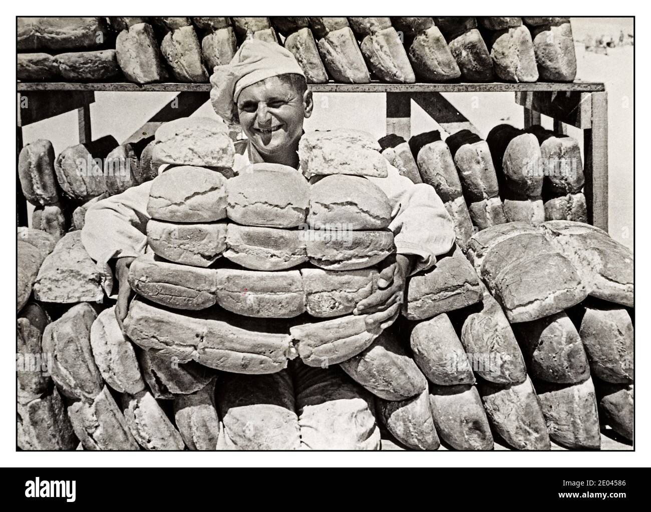 WW2 1941 UK Propaganda Food Poster UNA panetteria nel Western Desert Baker con pile di pani appena sfornati, tutti pronti per la consegna alle truppe. [Tra il 1940 e il 1942] Guerra Mondiale, 1939-1945 Bakers--1940-1950 pane--Egitto--deserto Occidentale--1940-1950 in una panetteria nel deserto Occidentale migliaia di pani sono cotti per il consumo delle truppe lì. Gli uomini che lavorano nella panetteria stavano facendo lo stesso lavoro in Francia, e tutti sono esperti nel loro settore della cottura. La campagna del deserto occidentale, nei deserti di Egitto e Libia e il teatro principale della campagna nordafricana Foto Stock