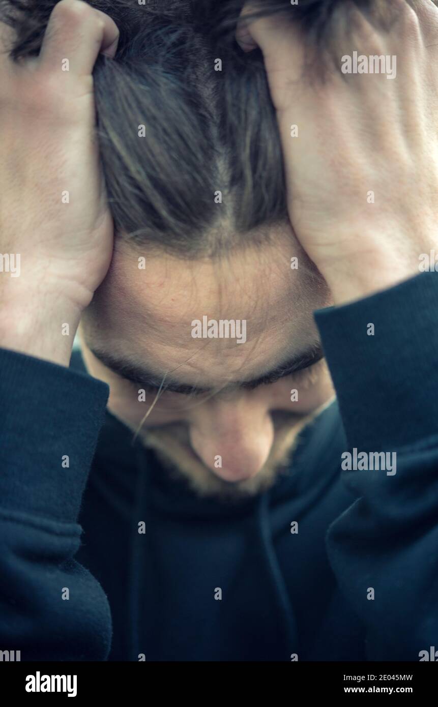 Frustrato giovane uomo con le mani sulla testa Foto Stock