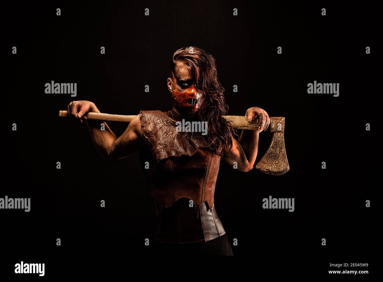 Selvaggi assassini che indossano una maschera in pelle, armati di un'ascia che porta sulle spalle Foto Stock
