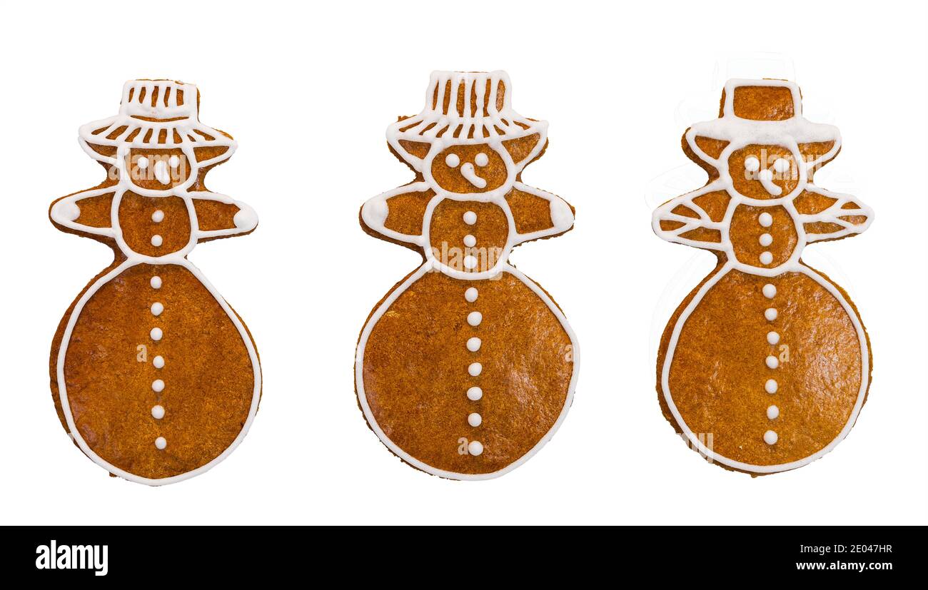 Set di pan di zenzero dolce a forma di pupazzo di neve isolato su sfondo bianco. Primo piano di tre graziosi biscotti natalizi decorati dalla glassa. Giocattolo per bambini al forno. Foto Stock