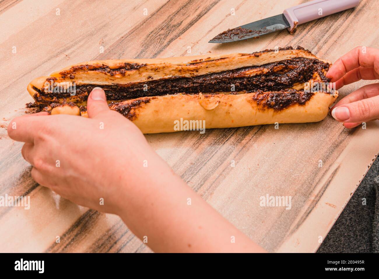 La mano della donna prepara l’impasto della torta al cioccolato per la cottura Foto Stock