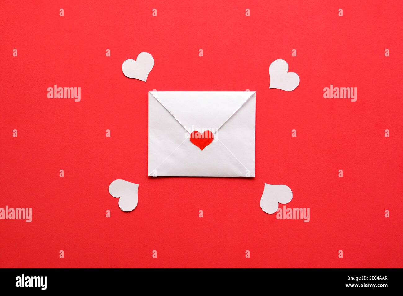 Carta valentina bianca con cuore rosso su sfondo rosso. Foto Stock