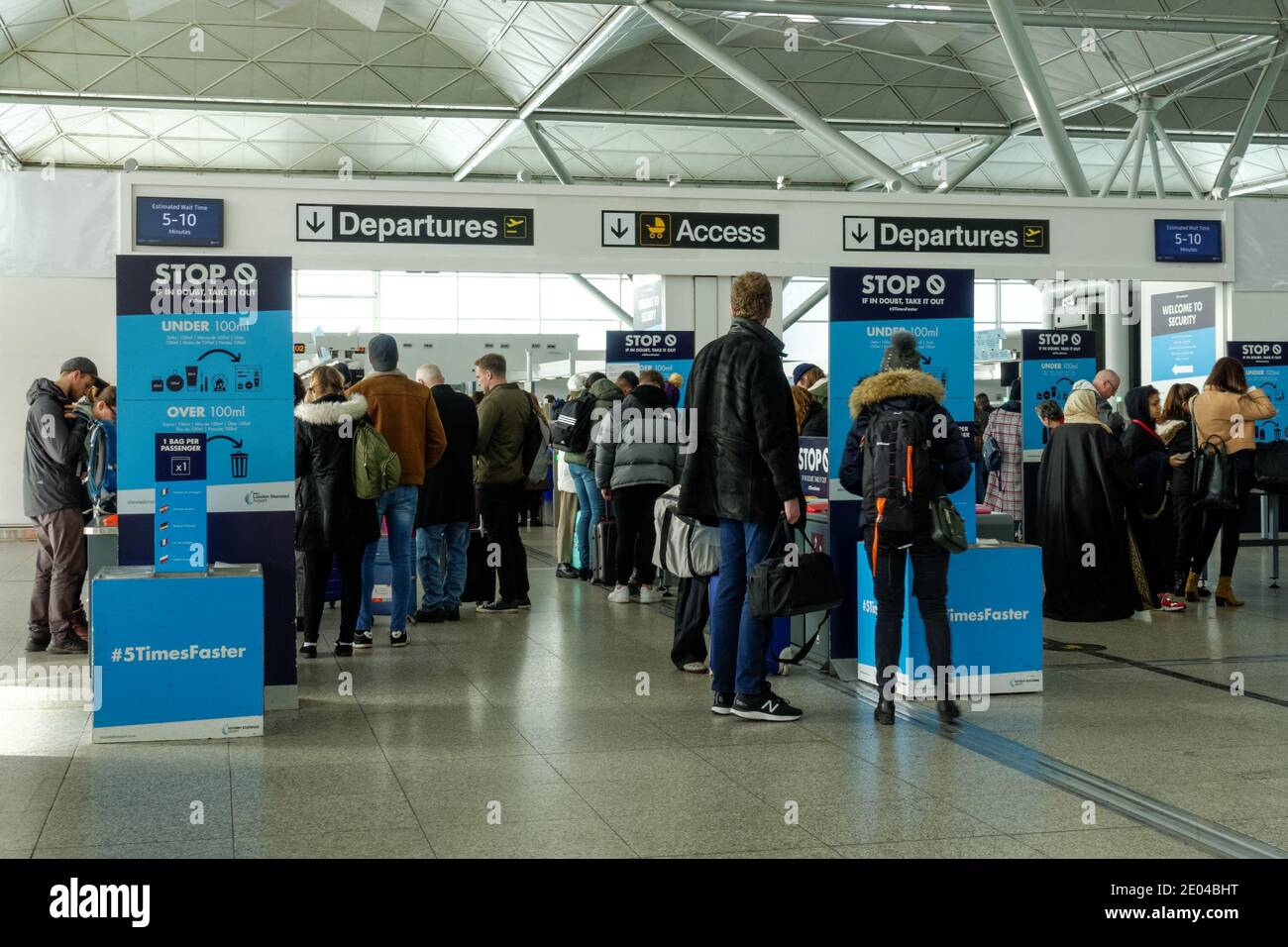 Passeggeri e viaggiatori che attraversano i cancelli di partenza dell'aeroporto di Londra Stansted Essex Inghilterra Regno Unito Regno Unito Foto Stock