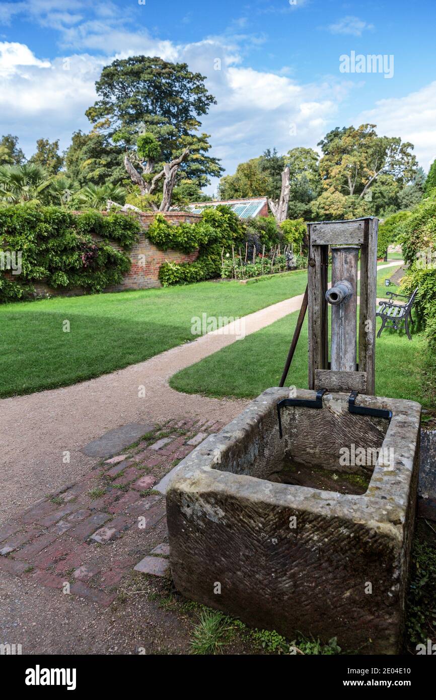Un vecchio canale di acqua di pietra con una pompa manuale di piombo nel giardino murato a Calke Abbey, Ticknall, Derbyshire, Inghilterra, Regno Unito. Foto Stock
