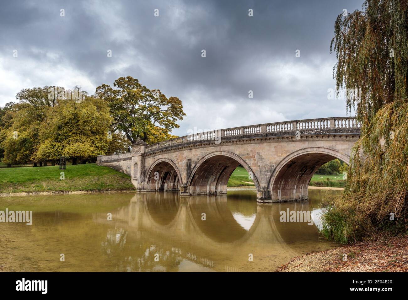 Il Ponte del Leone, un 18 ° secolo, costruito in pietra che attraversa il lago fermo sulla proprietà Burghley House. Stamford, Lincolnshire, Inghilterra, Regno Unito. Foto Stock
