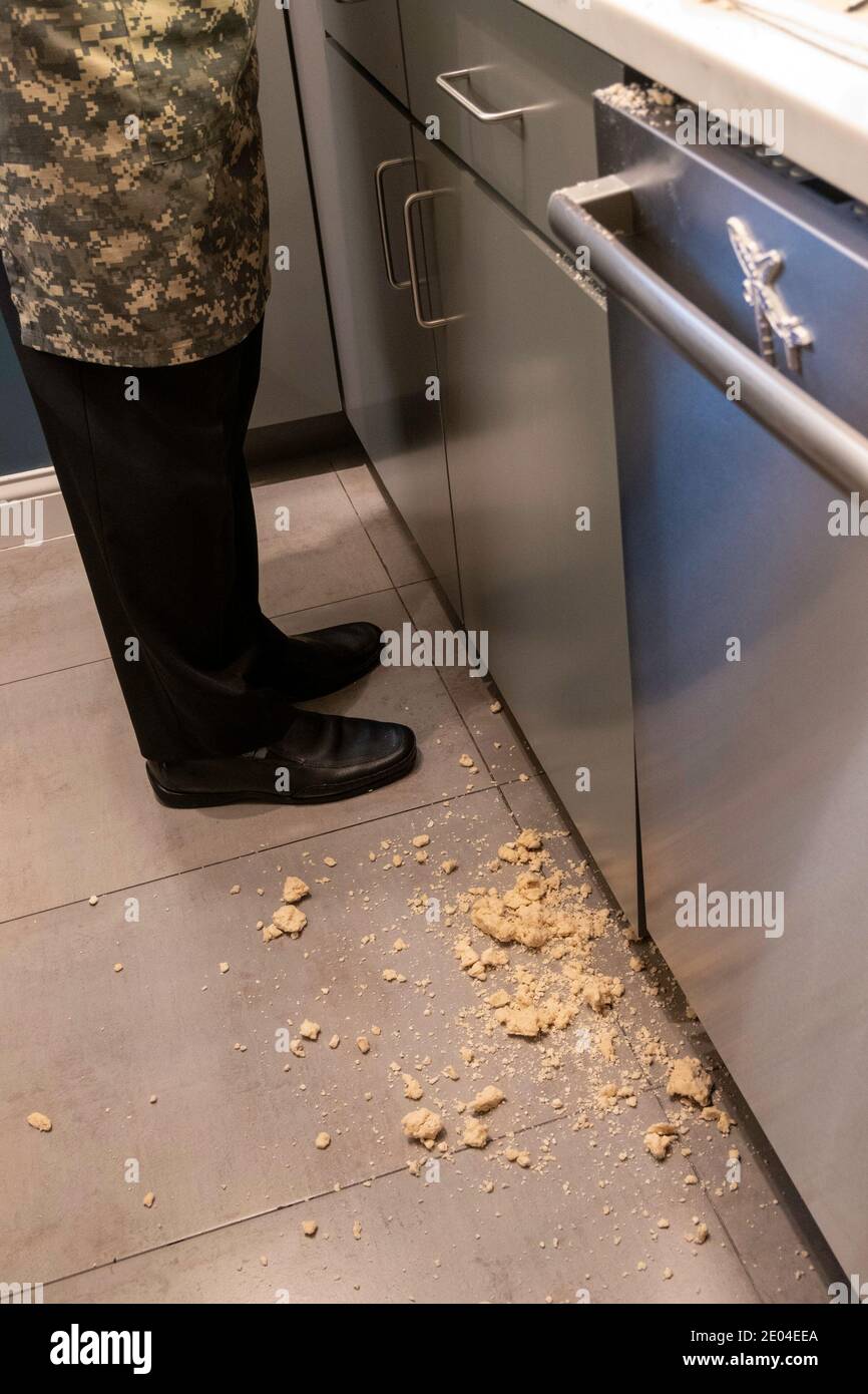 Uomo in piedi in una cucina circondata da un Mess versato. NEW YORK, STATI UNITI Foto Stock