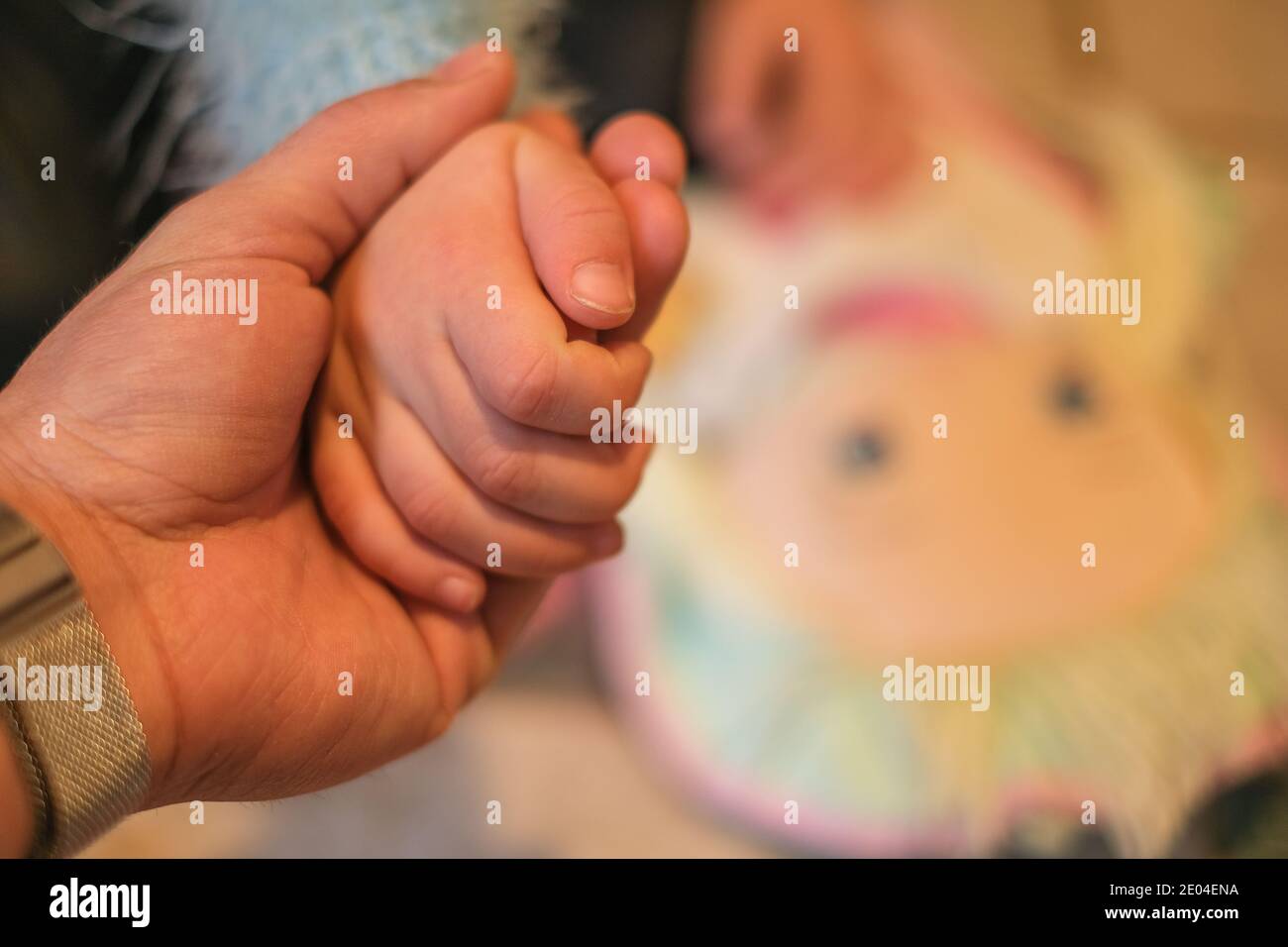 Il padre tiene la mano della figlia del bambino piccolo, concetto domestico di amore di educazione della famiglia Foto Stock