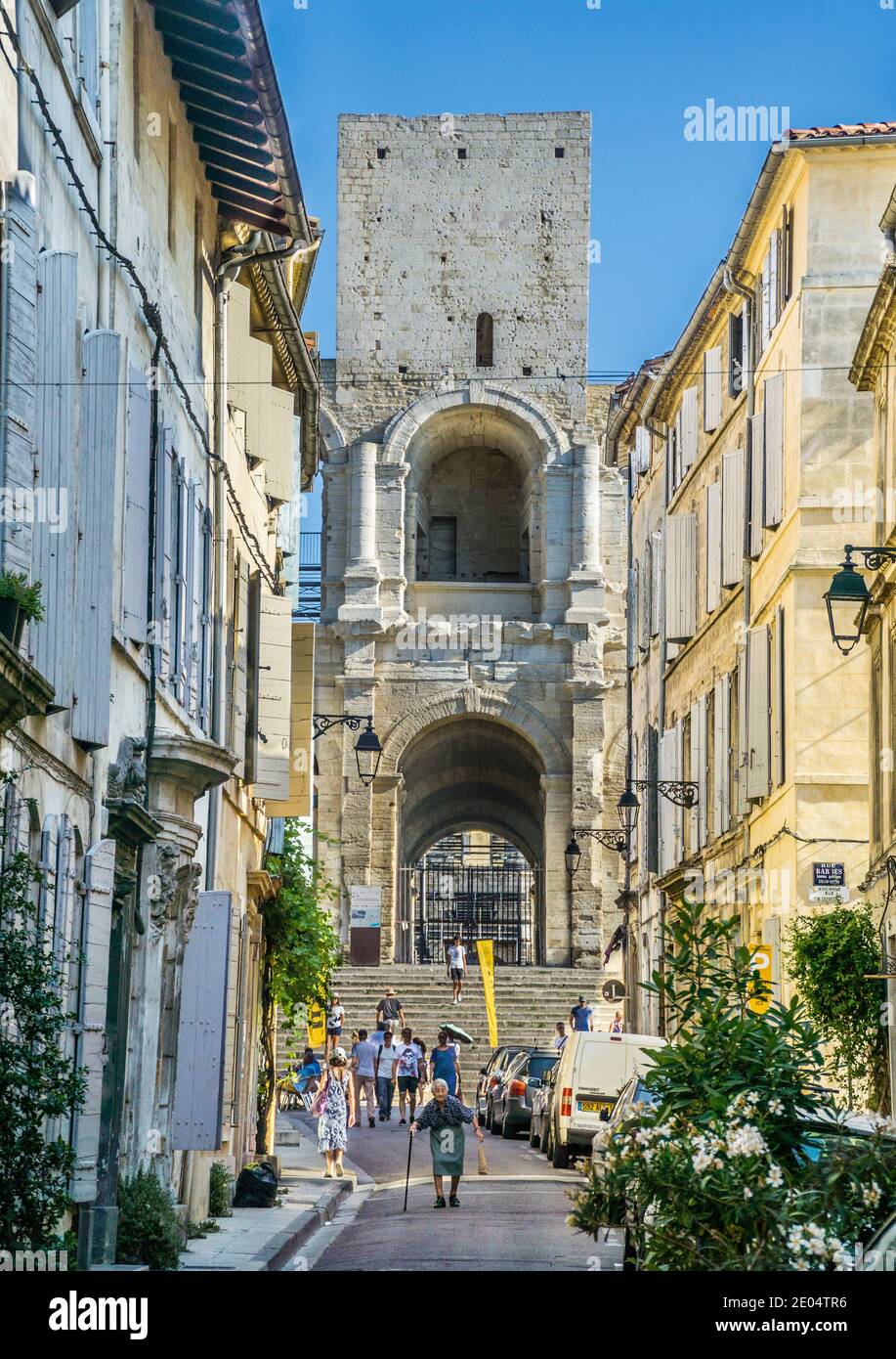 Vista verso l'Anfiteatro di Arles con torre medievale da Rue de l'Amphithéâtre, nell'antica città di Arles, Bouches-du-Rhône, Fra sud Foto Stock