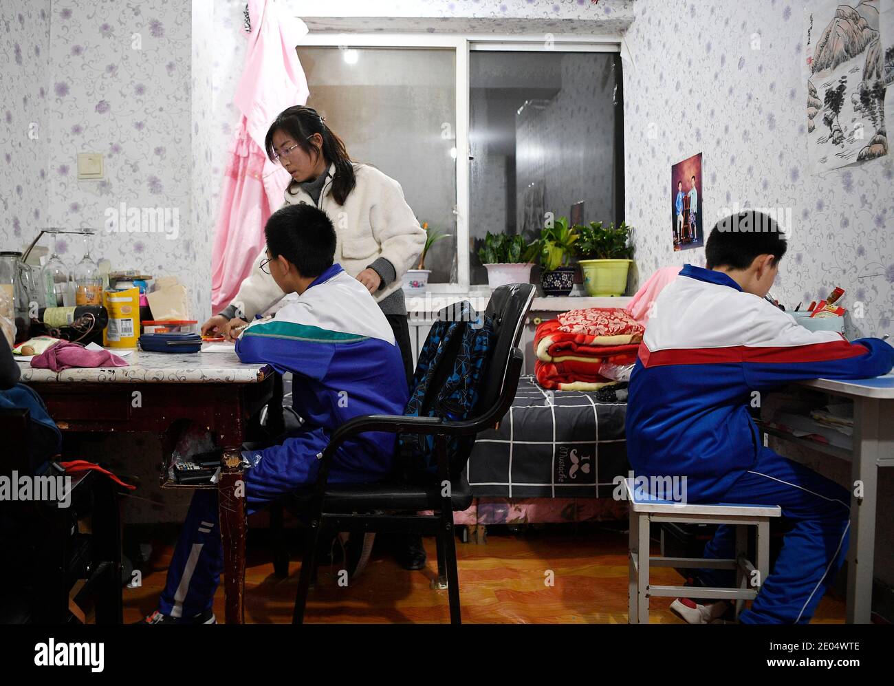 (201230) -- YINCHUAN, 30 dicembre 2020 (Xinhua) -- Feng Yahong tutor i suoi figli in una casa affittata nella contea di Xiji, nella regione autonoma di Ningxia Hui, nel nord-ovest della Cina, 29 ottobre 2020. Xihaigu, una delle aree più povere della Cina, situata a Ningxia, ha visto la sua ultima contea impoverita rimossa dalla lista nazionale della povertà il 16 novembre 2020. La vittoria è un altro punto di riferimento nella campagna cinese per sradicare la povertà assoluta, durante la quale il 'potere' ha svolto un ruolo indispensabile. Feng Yahong, una donna rurale di 33 anni che vive nelle zone, ha aiutato molte donne locali a liberarsi della povertà portando t Foto Stock