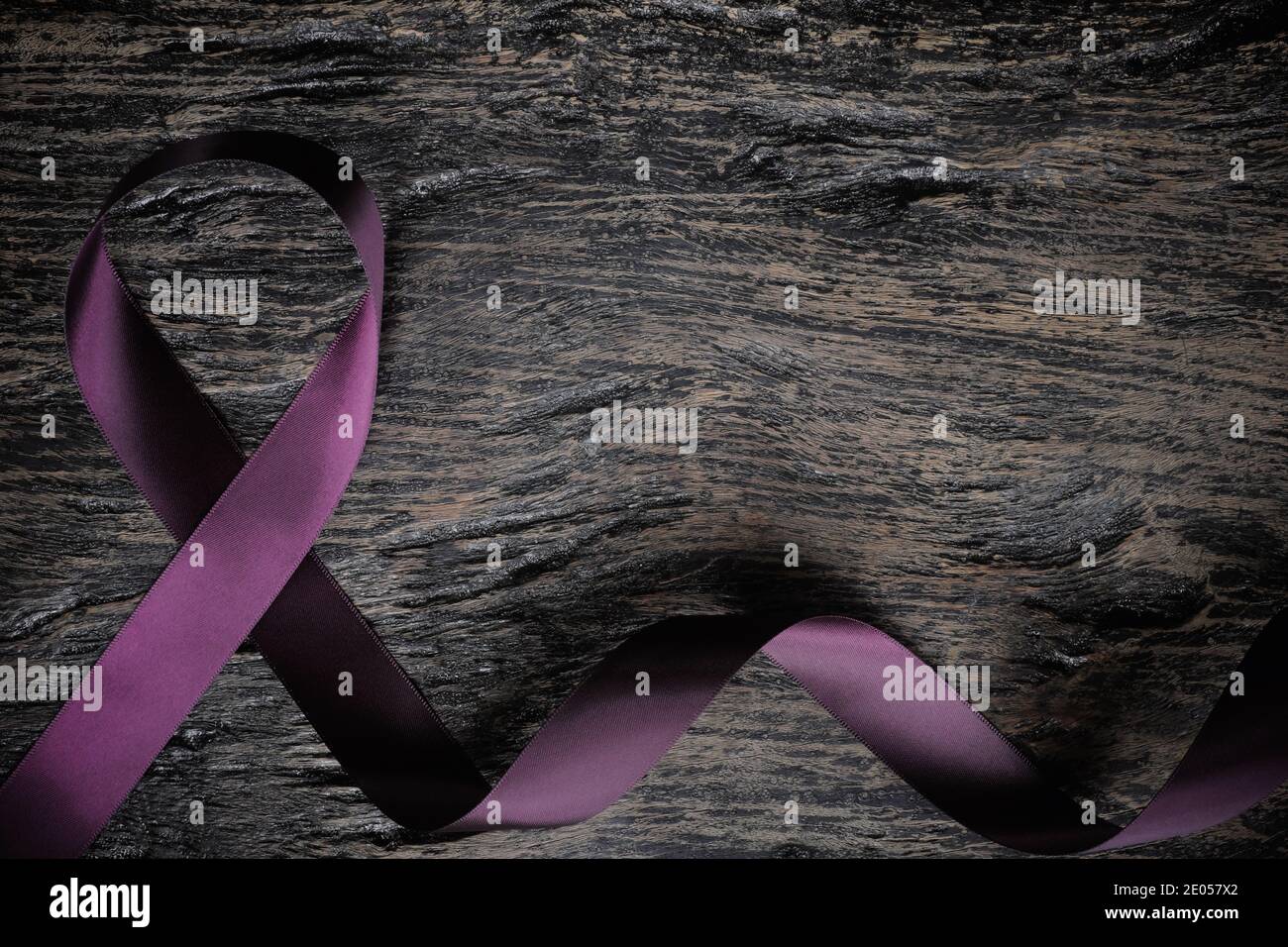 Vista dall'alto del nastro viola su sfondo di legno con spazio per la copia. Cancro del pancreas, epilessia, leiomiosarcoma, lupus, morbo di Alzheimer e cistico Foto Stock