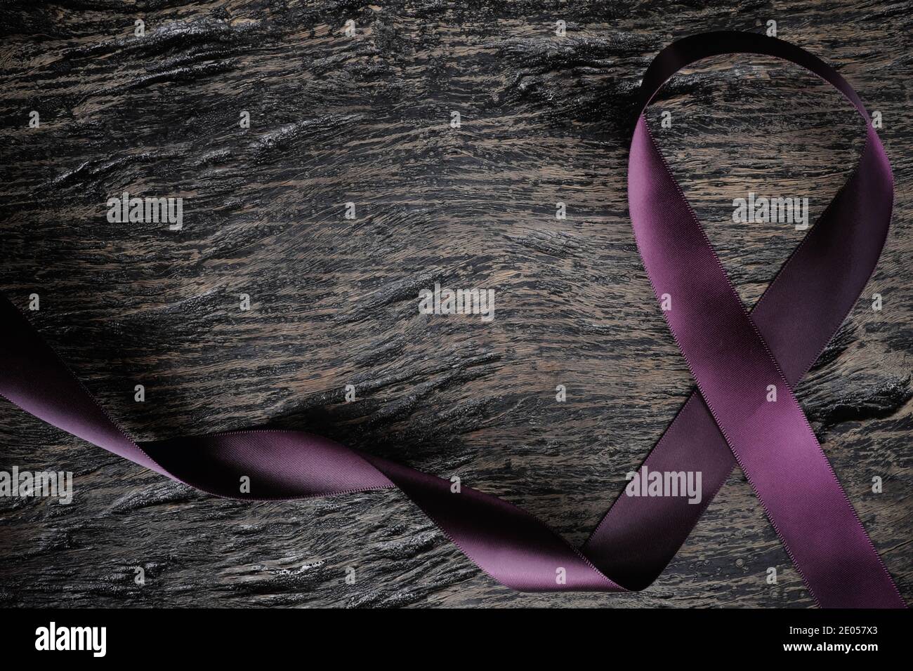 Vista dall'alto del nastro viola su sfondo di legno con spazio per la copia. Cancro del pancreas, epilessia, leiomiosarcoma, lupus, morbo di Alzheimer e cistico Foto Stock