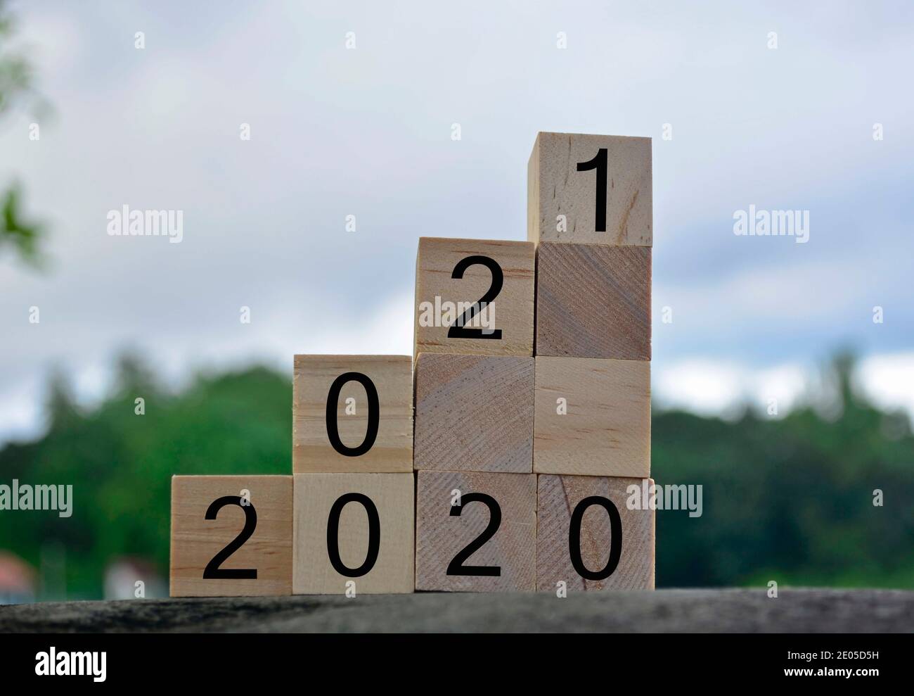 numero 2020 e 2021 su blocco di legno con sfondo sfocato. 2021 concetto di nuovo anno Foto Stock