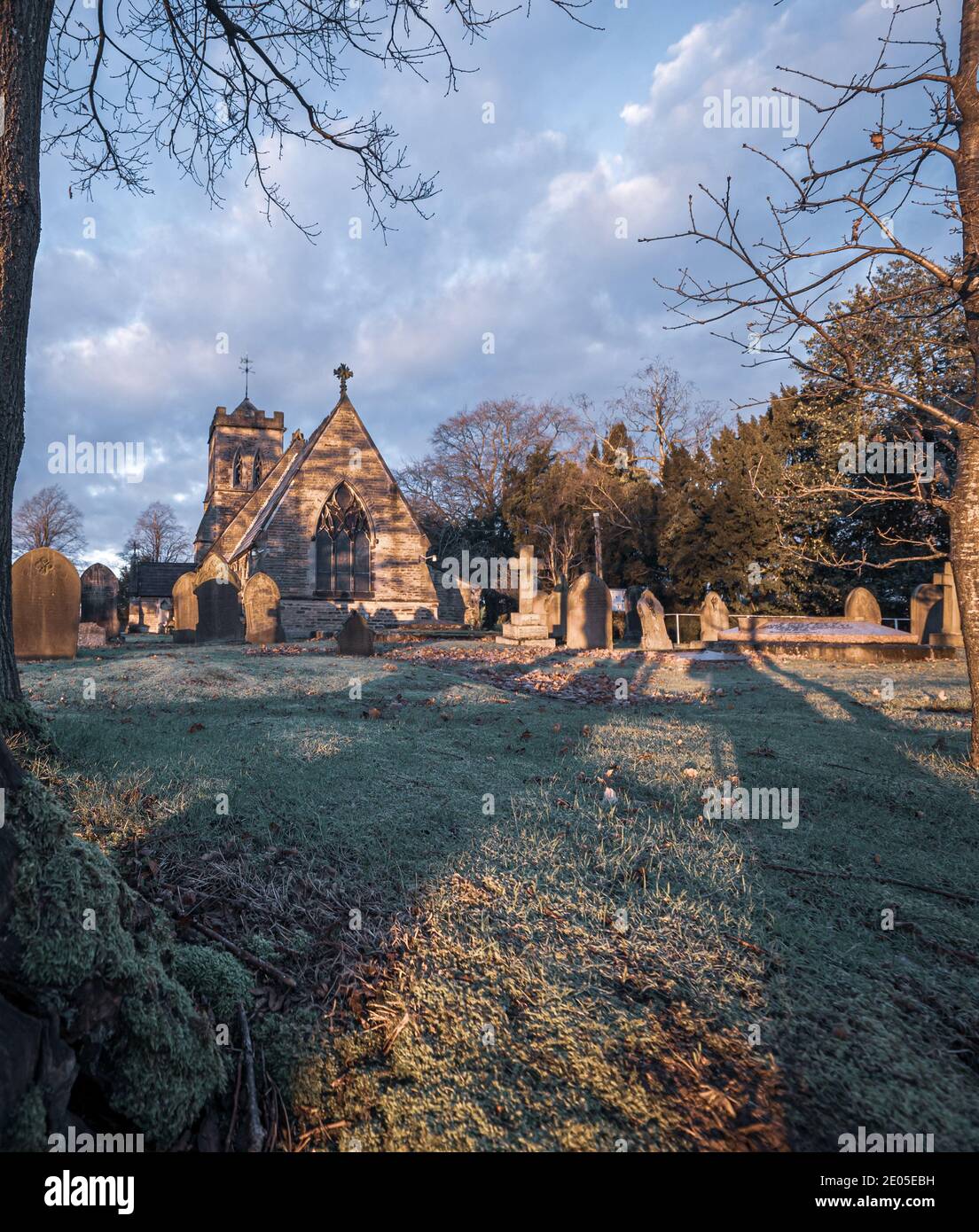 Un'immagine solenne di lapidi in un cortile della chiesa su una nebbiosa Moody alba. Foto Stock