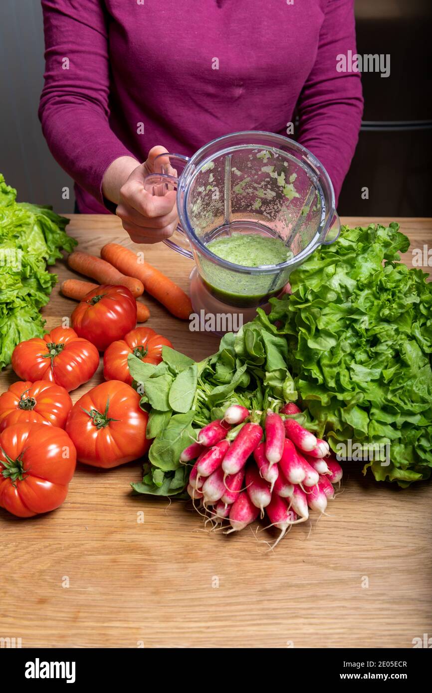 Donna vegana che fa succo vegetale per disintossicare Foto Stock
