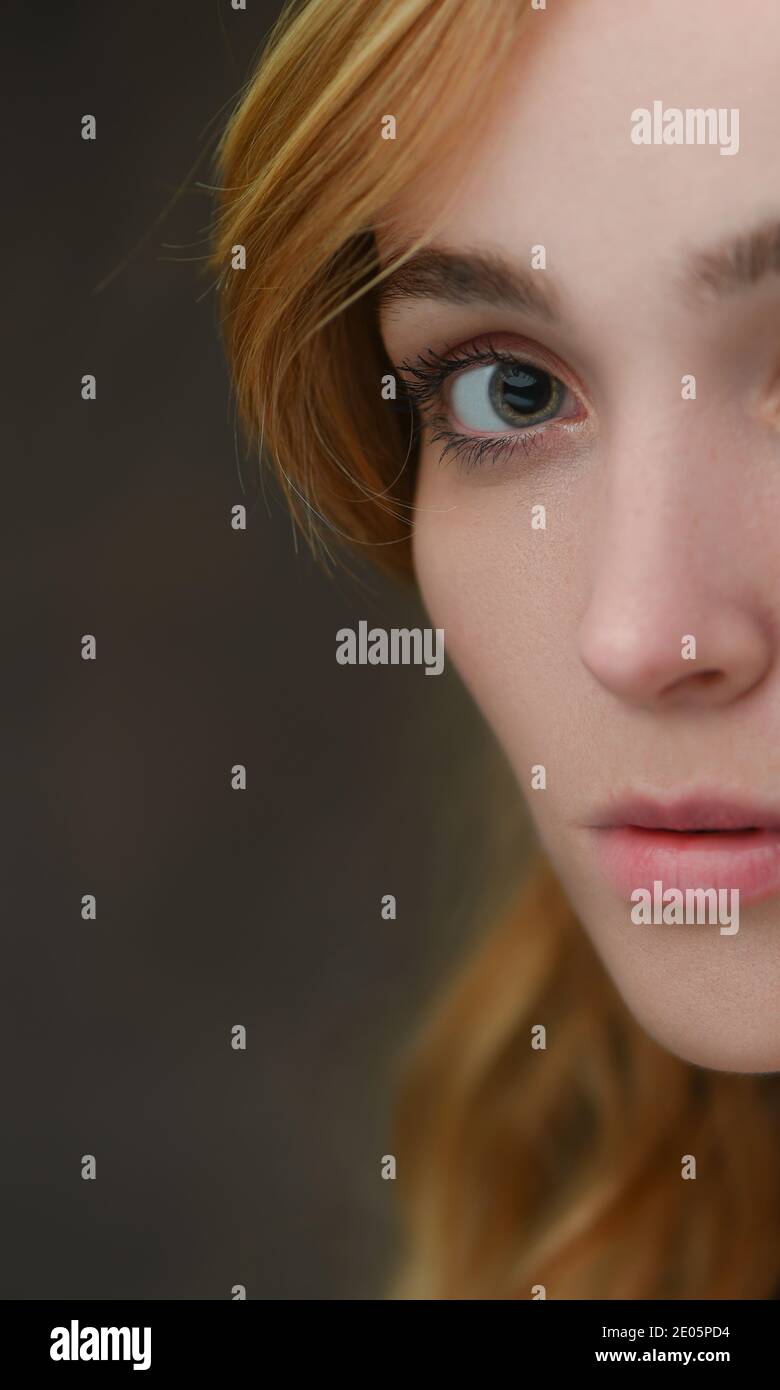 Primo piano (metà del viso) di una donna naturalmente bella con buona pelle e caratteristiche forti (20) focalizzata sull'occhio con contatto diretto con lo spazio di copia. Foto Stock