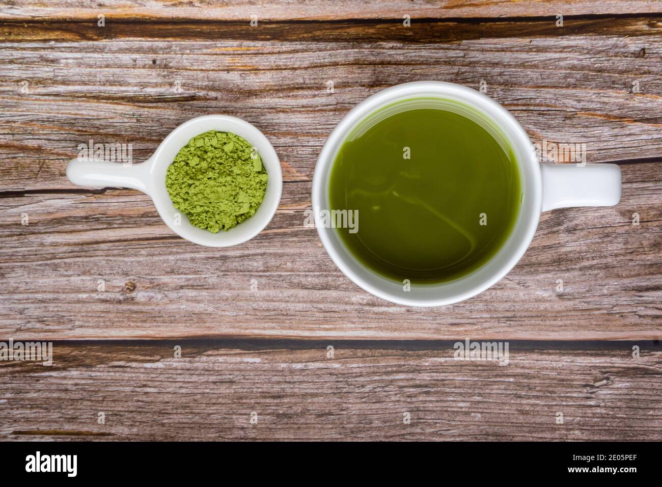 tazza di tè matcha e tè verde matcha in polvere in una piccola ciotola su un tavolo di legno. Vista dall'alto. Spazio per il testo. Concetto di cibo sano Foto Stock