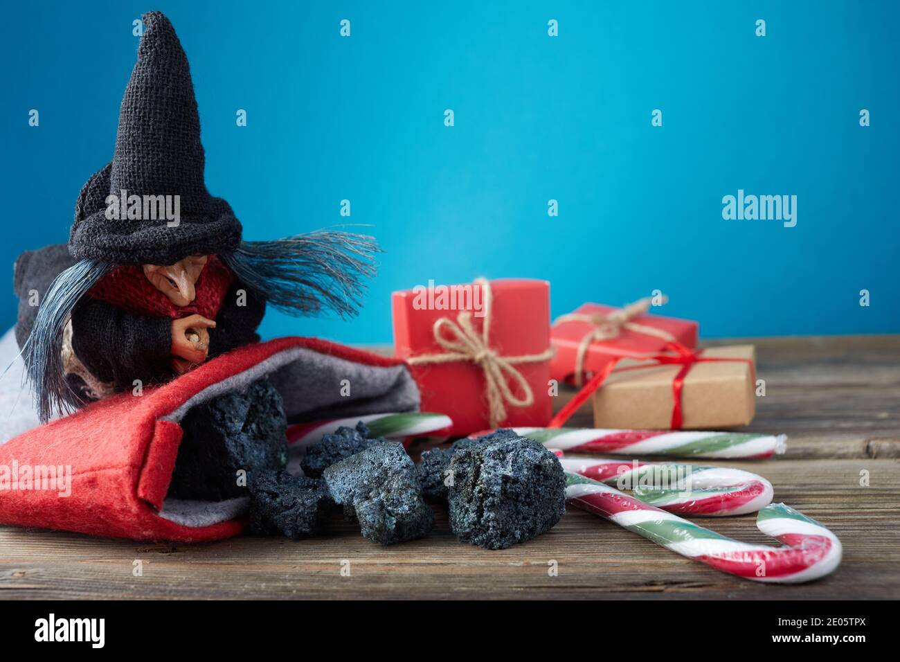 La Befana con carbone dolce e caramelle su sfondo di legno. Tradizione italiana dei giorni dell'Epifania. Foto Stock
