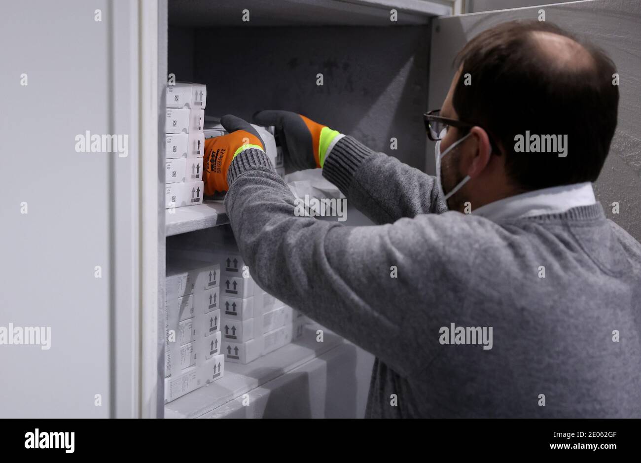 Irxleben, Germania. 30 dicembre 2020. Il farmacista Boris A. Osmann prende il vaccino corona dalla società Biontech con sede a Mainz e dal suo partner statunitense Pfizer da un congelatore a bassissimo livello nel magazzino dei vaccini di Börde. In Sassonia-Anhalt, la vaccinazione contro il virus Corona è ufficialmente in corso da alcuni giorni. Inizialmente, i team mobili stanno fornendo residenti e personale nelle case di cura e dipendenti ospedalieri. Credit: Ronny Hartmann/dpa/Alamy Live News Foto Stock