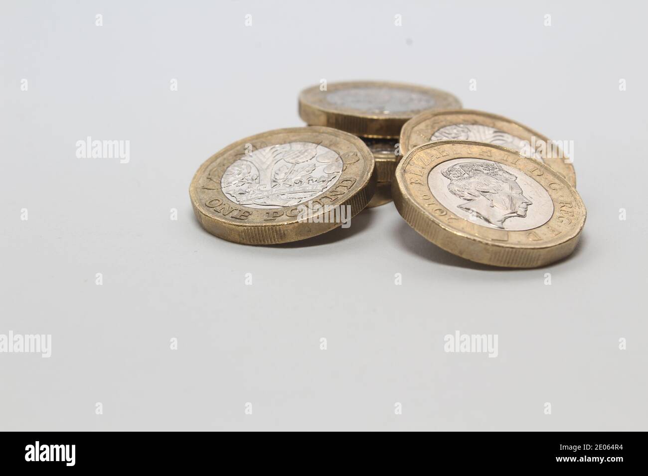 Monete nuove da una libbra di sterline isolate su sfondo bianco, monete in valuta britannica Foto Stock