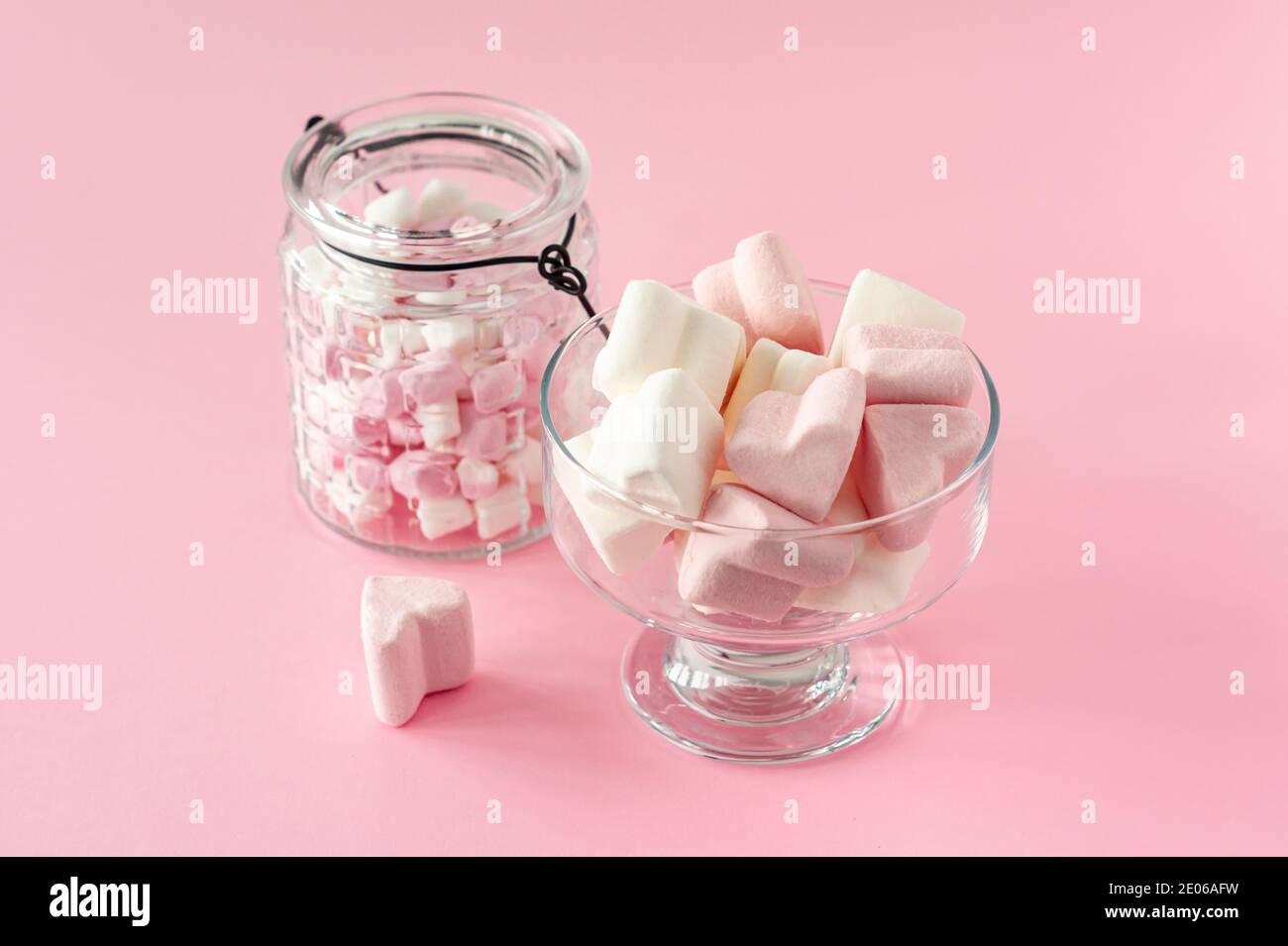 marshmallow forma del cuore e mini con concetto di amore su sfondo rosa. Foto Stock