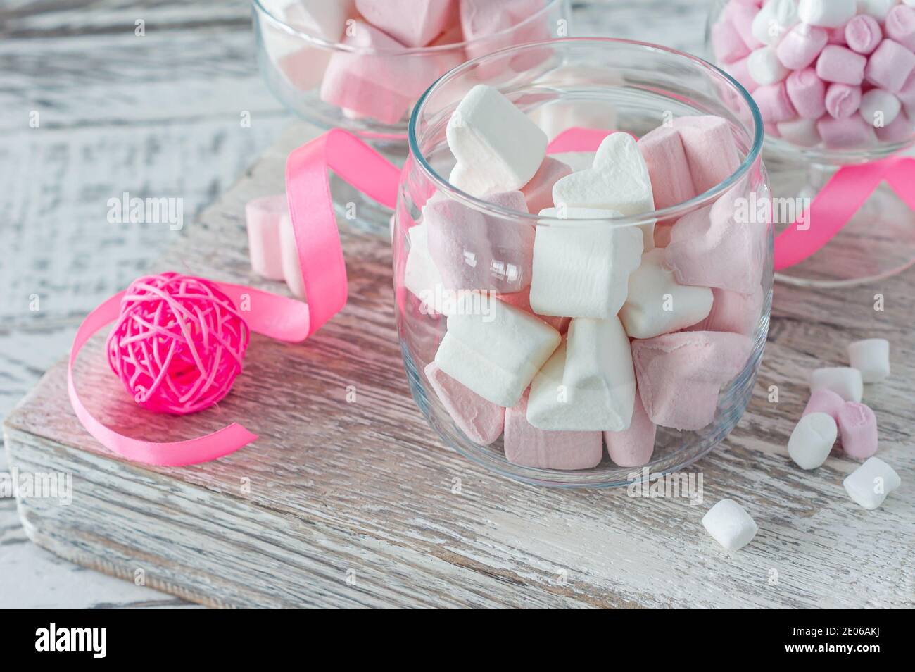 Ciotola con gustosi marshmallow e nastro rosa su tavola bianca, primo piano. Foto Stock