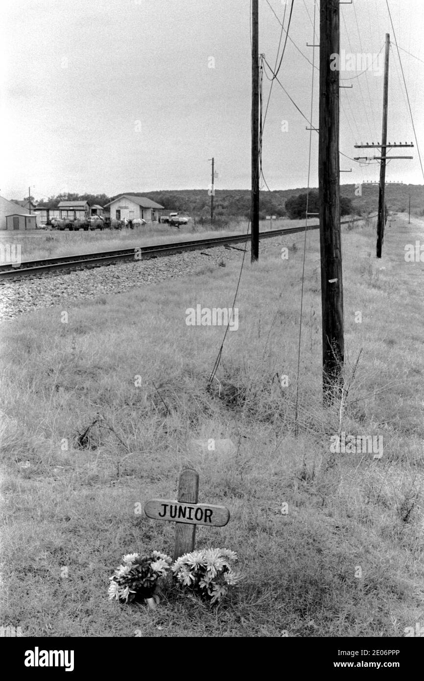 Una semplice croce e fiori rende il luogo dove Junior Morì oltre ad una ferrovia 1999 Santo, Texas anni '90 USA OMERO SYKES Foto Stock