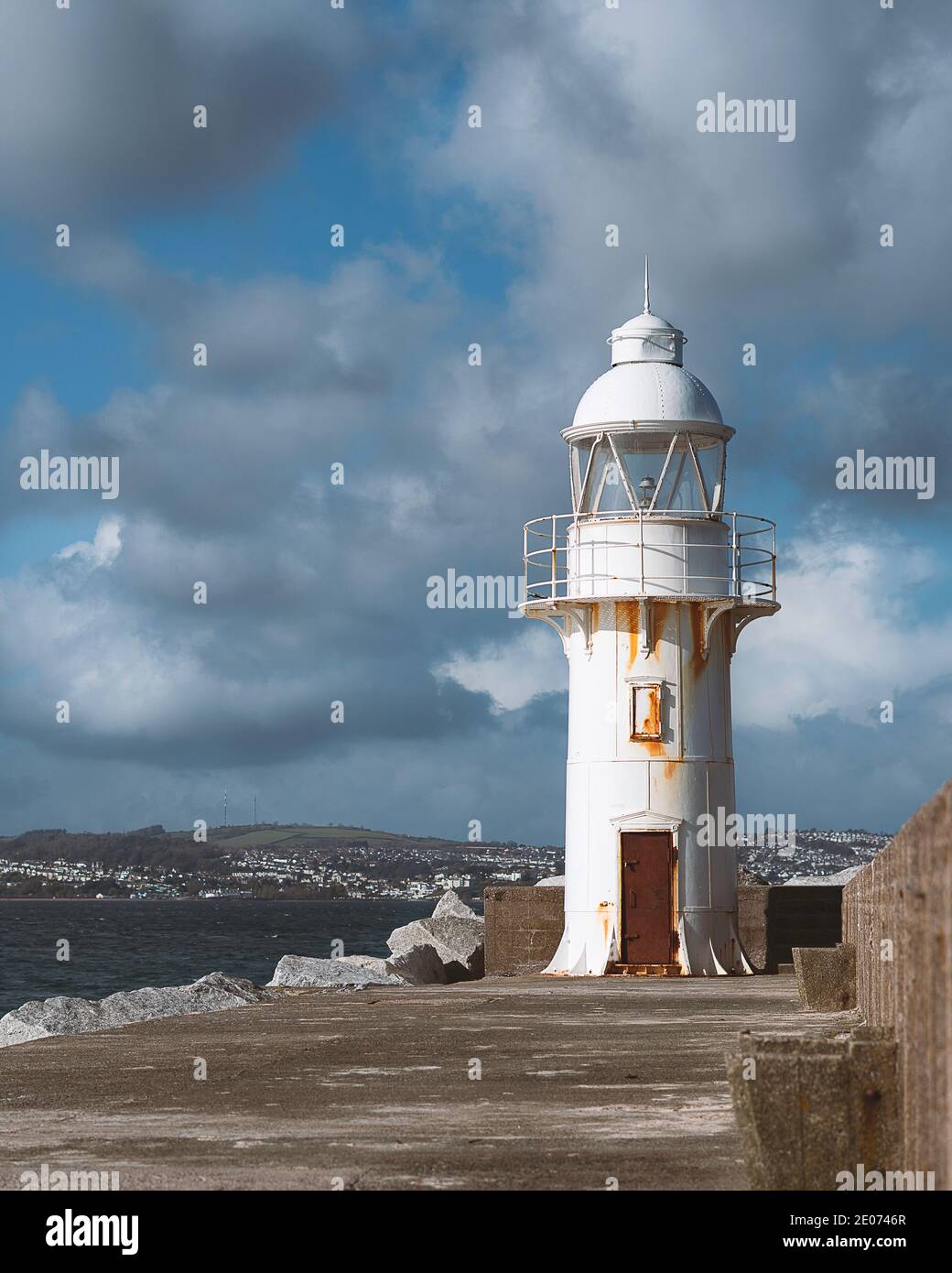 Paesaggio balneare con piccolo faro bianco sul fronte in pietra Sentiero molo fuori al mare a Brixham in Devon La costa inglese Foto Stock