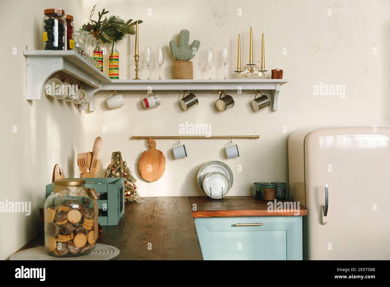 Interni rustici della cucina: Piano di legno con frigorifero retrò, mensole con tazze e utensili, colori pastello tenui. Foto Stock