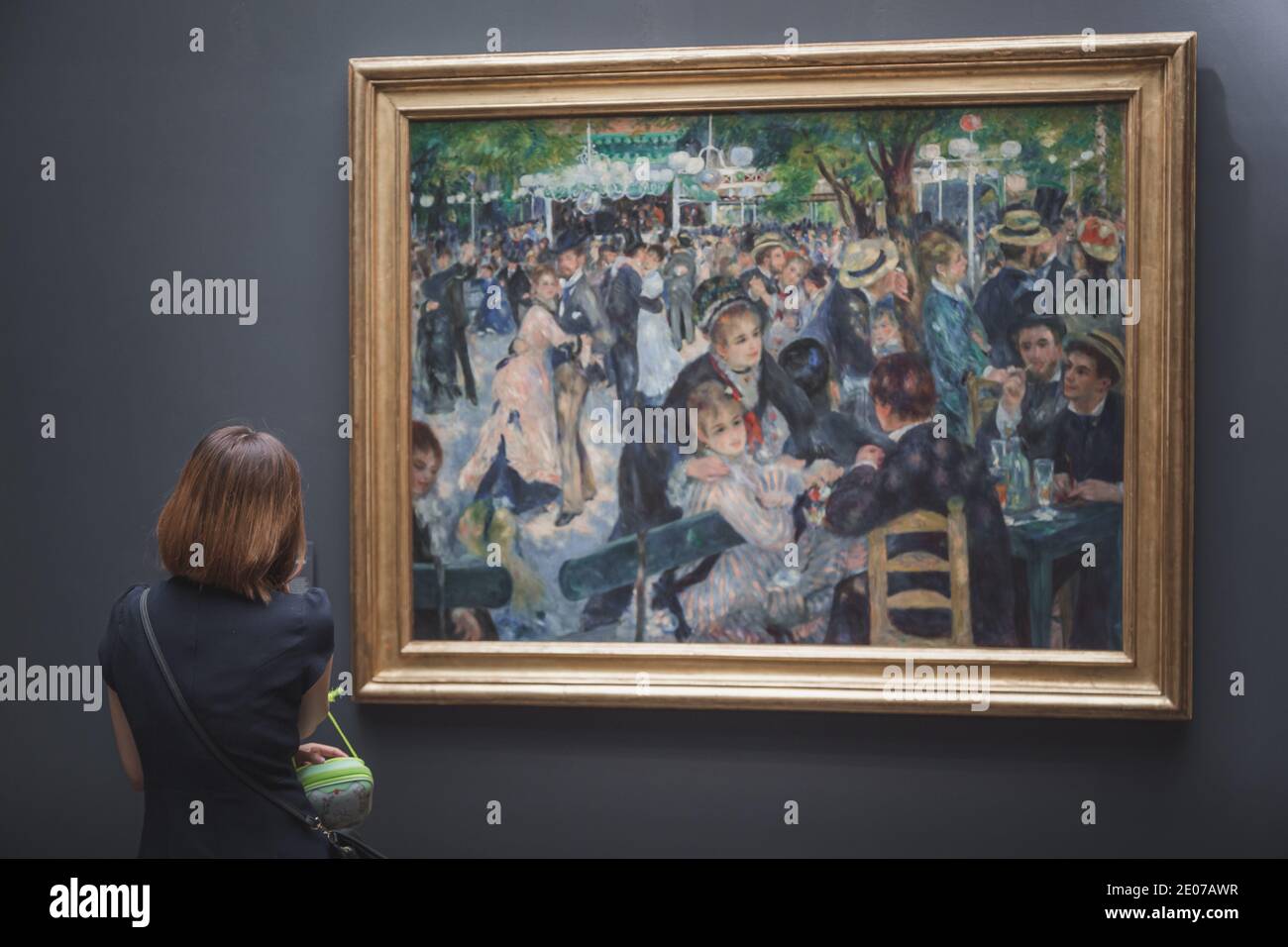 Parigi, Francia - 22 agosto 2015: Un visitatore del Musee d'Orsay che guarda il famoso capolavoro di Renoir "Bal du moulin de la Galette" Foto Stock