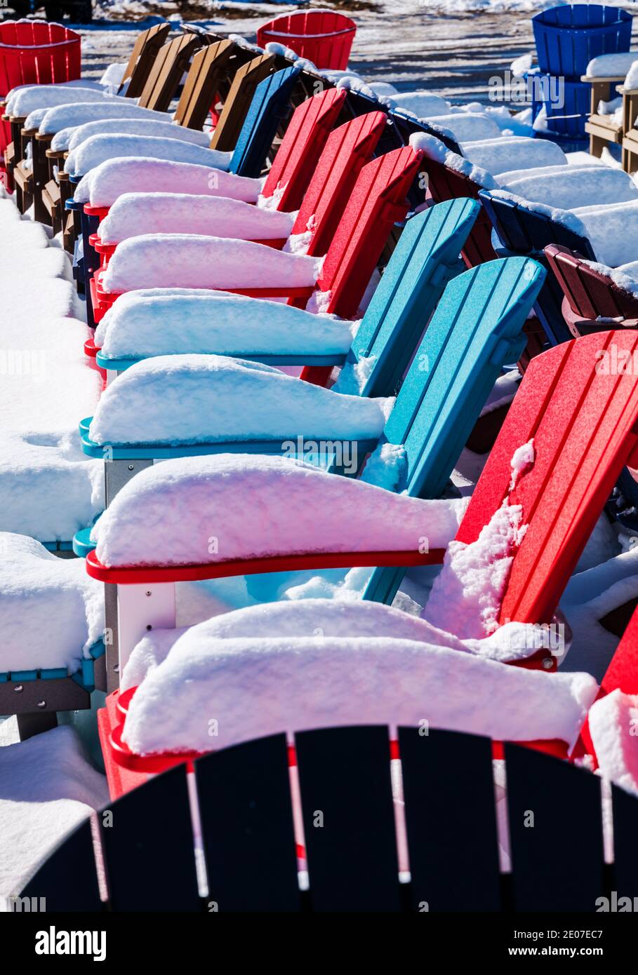 Sedie colorate in stile Adirondack nella neve fresca; negozio al dettaglio; Poncha Springs; Colorado; USA Foto Stock