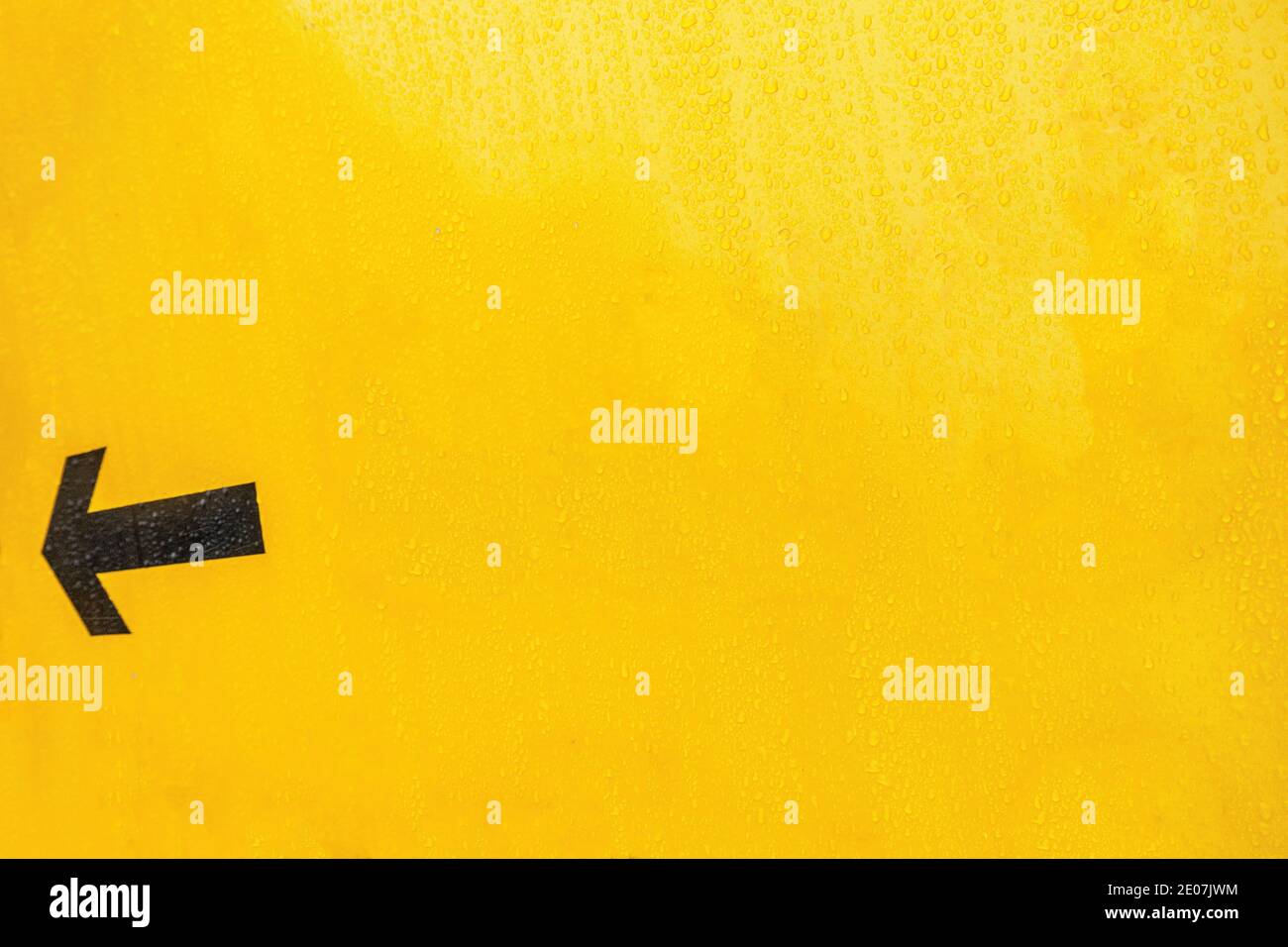 Freccia nera su un cartello giallo in Inghilterra Foto Stock