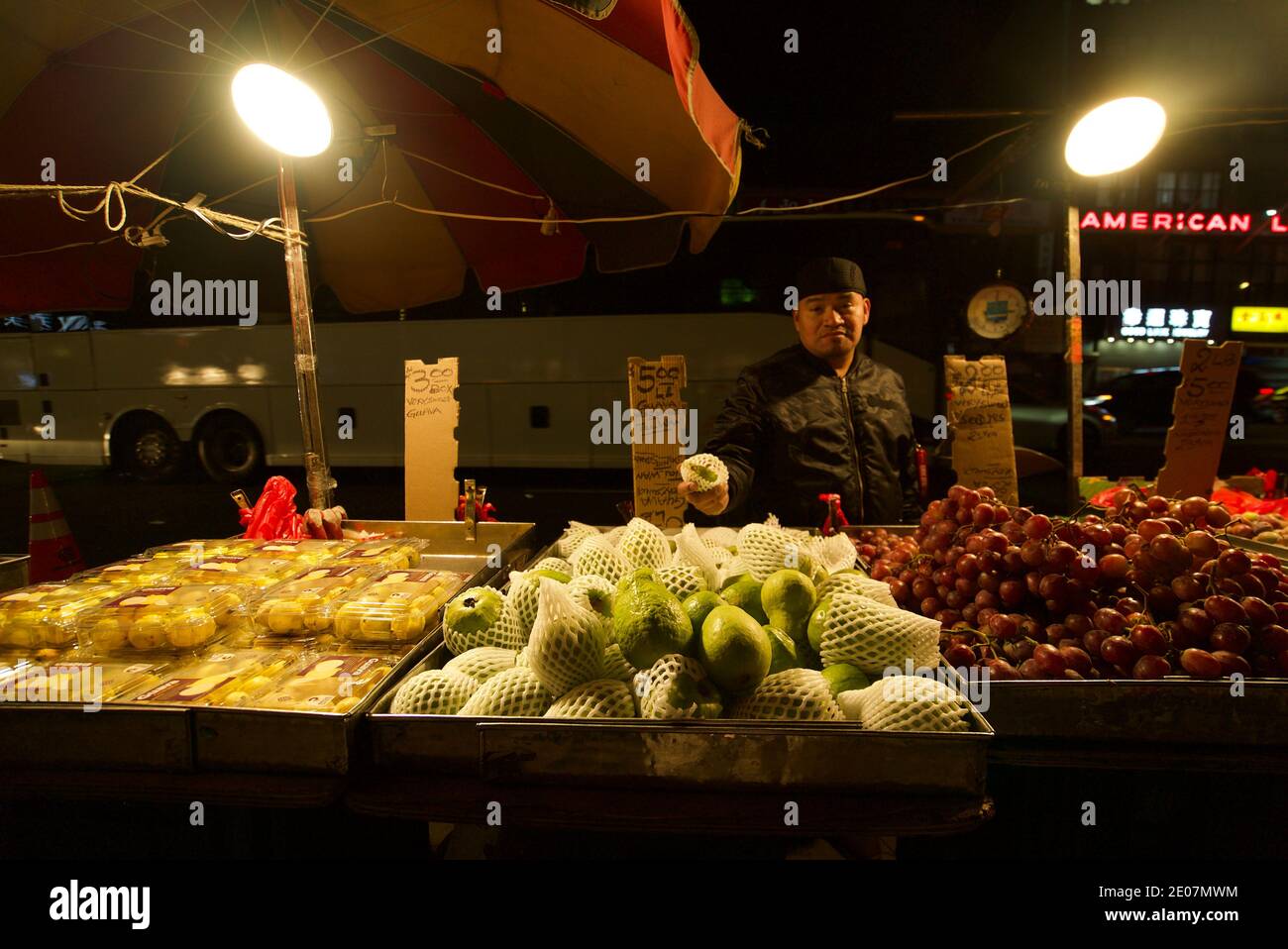 Un venditore di strada a Chinatown, New York, che vende frutta Guava e altri frutti. Un uomo che vende frutta in un mercato a New York, in China Town. Bowery. Foto Stock