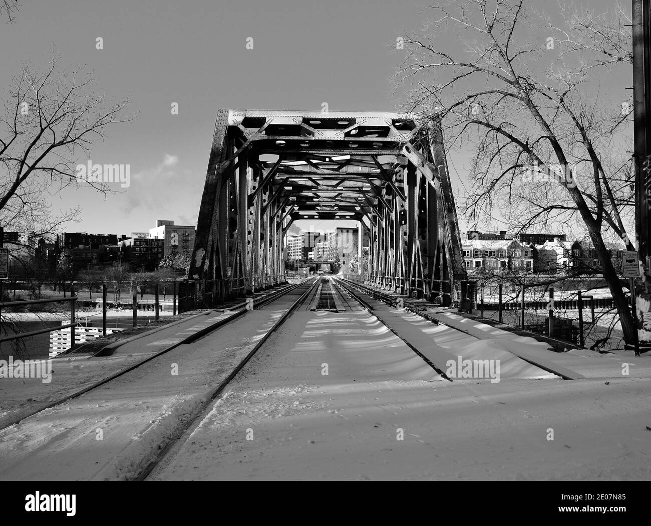 vista ad angolo basso del lungo ponte ferroviario sul fiume in inverno Foto Stock