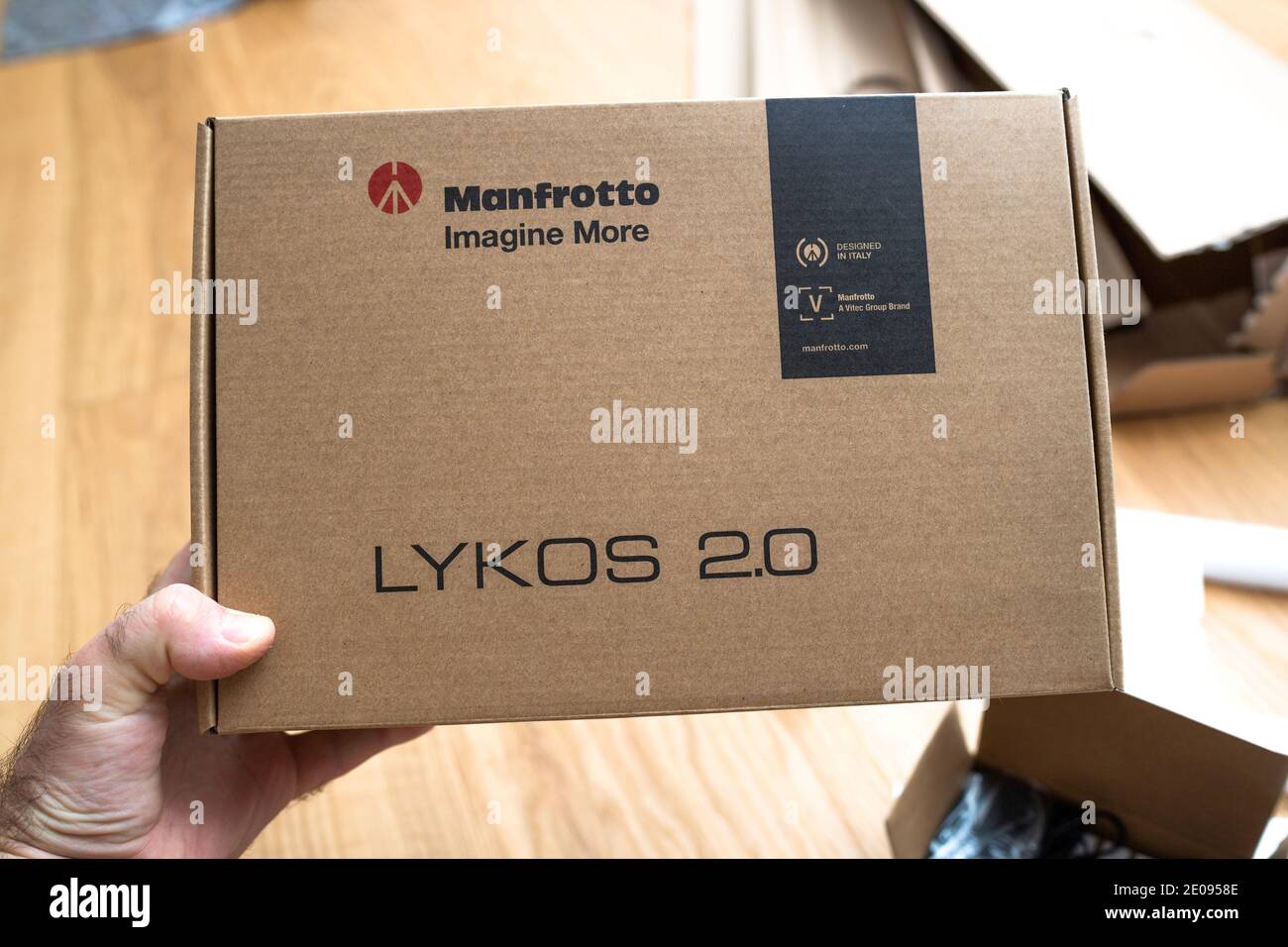 Parigi, Francia - 8 dic 2020: POV scatola porta mano maschio prima di disimballare il nuovo Manfrotto LED Light Lykos 2.0, 2 in 1 impermeabile con Bluetooth - progettato in italia dal gruppo Vitec Foto Stock