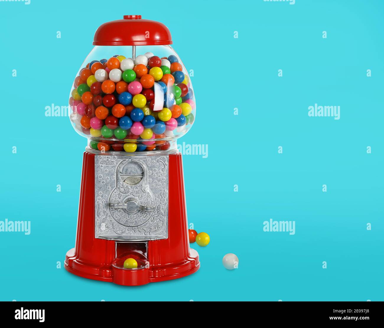 Macchina GUM Ball. Rosso e Argento con gumball colorate e luminose. Sfondo blu acqua. Distributore di caramelle per bambini. Giochi per bambini. Foto Stock