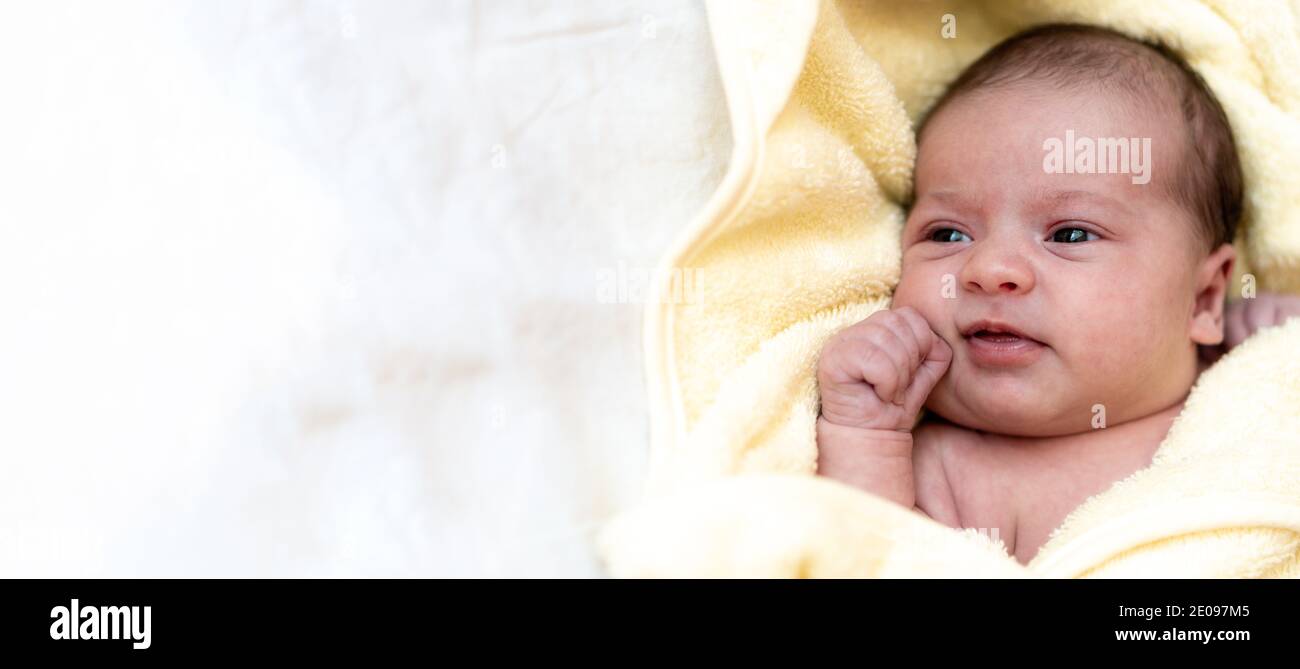 Infanzia, cura, igiene, maternità, innocenza concetti - banner Close up cute wet clean awake neonato dopo aver preso la doccia avvolto in caldo Foto Stock
