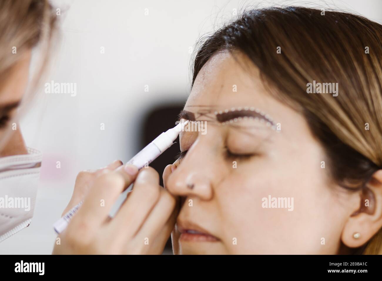 Cosmetologa latina che si prepara alla donna messicana per la procedura di trucco  permanente sopracciglia in Messico, closeup Microblading Foto stock - Alamy